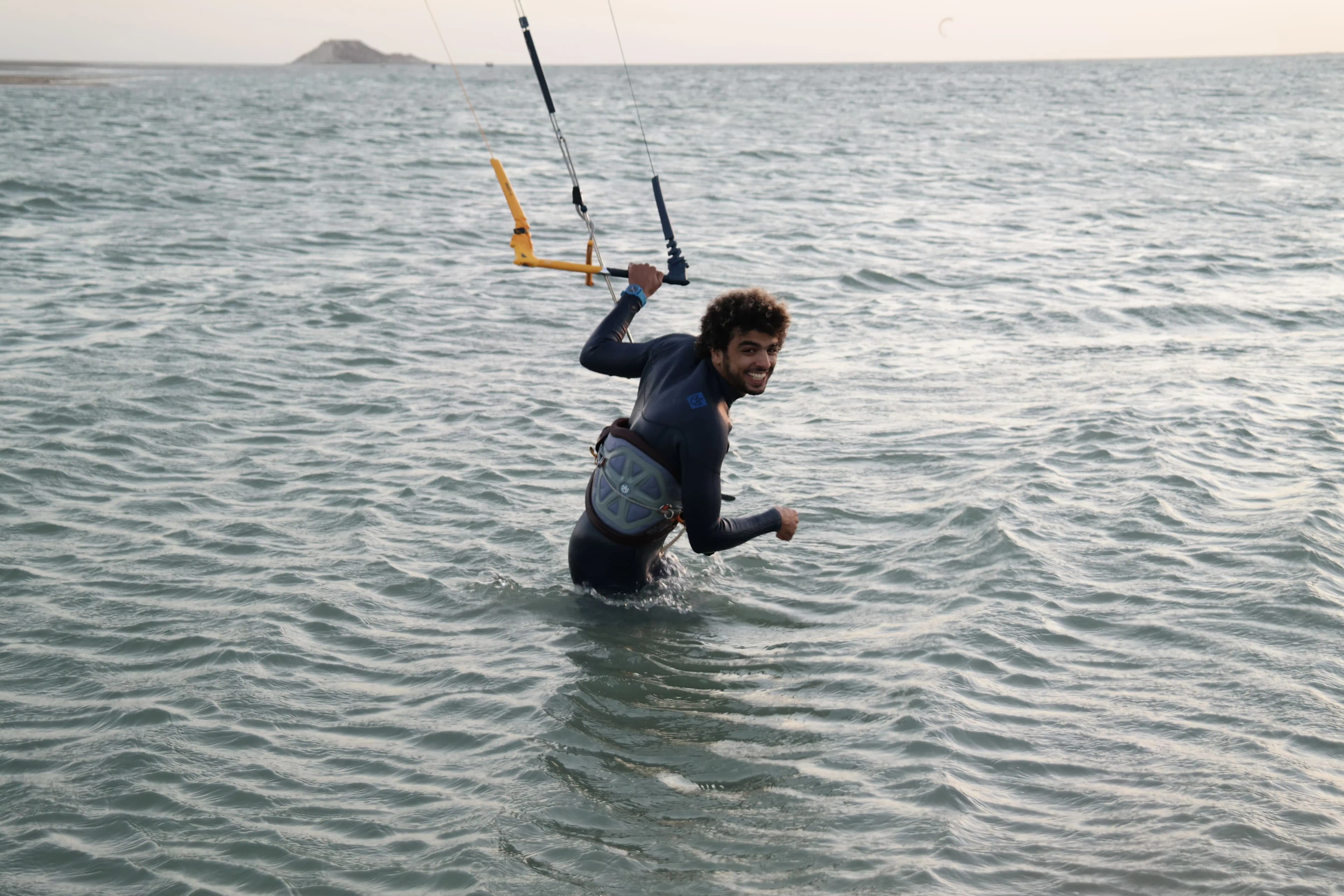A smiling Bluboarding instructor in the Dakhla water, ready to share the passion of kitesurfing with a student.