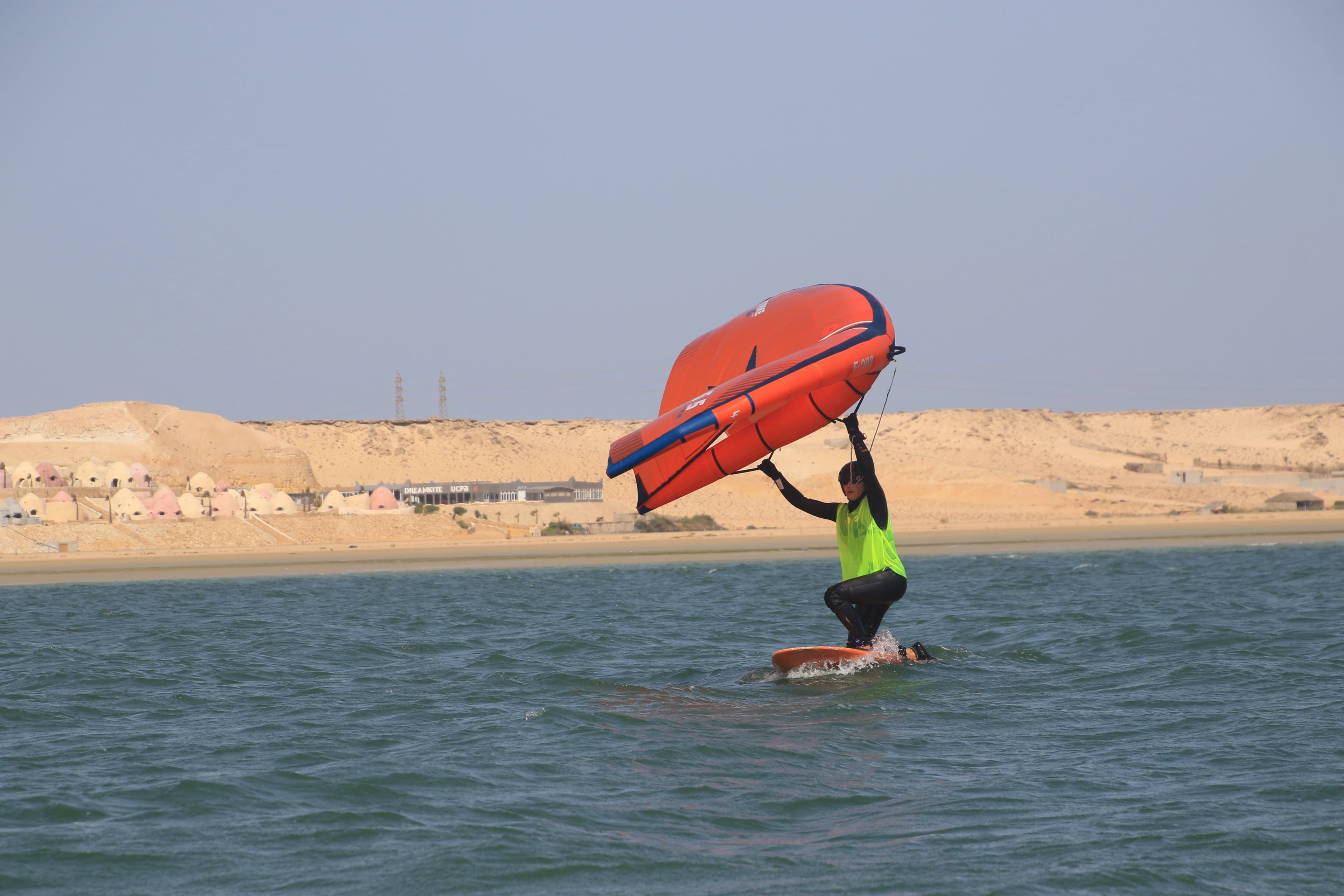 Wingfoil beginner learning to stand up on the board in Dakhla lagoon
