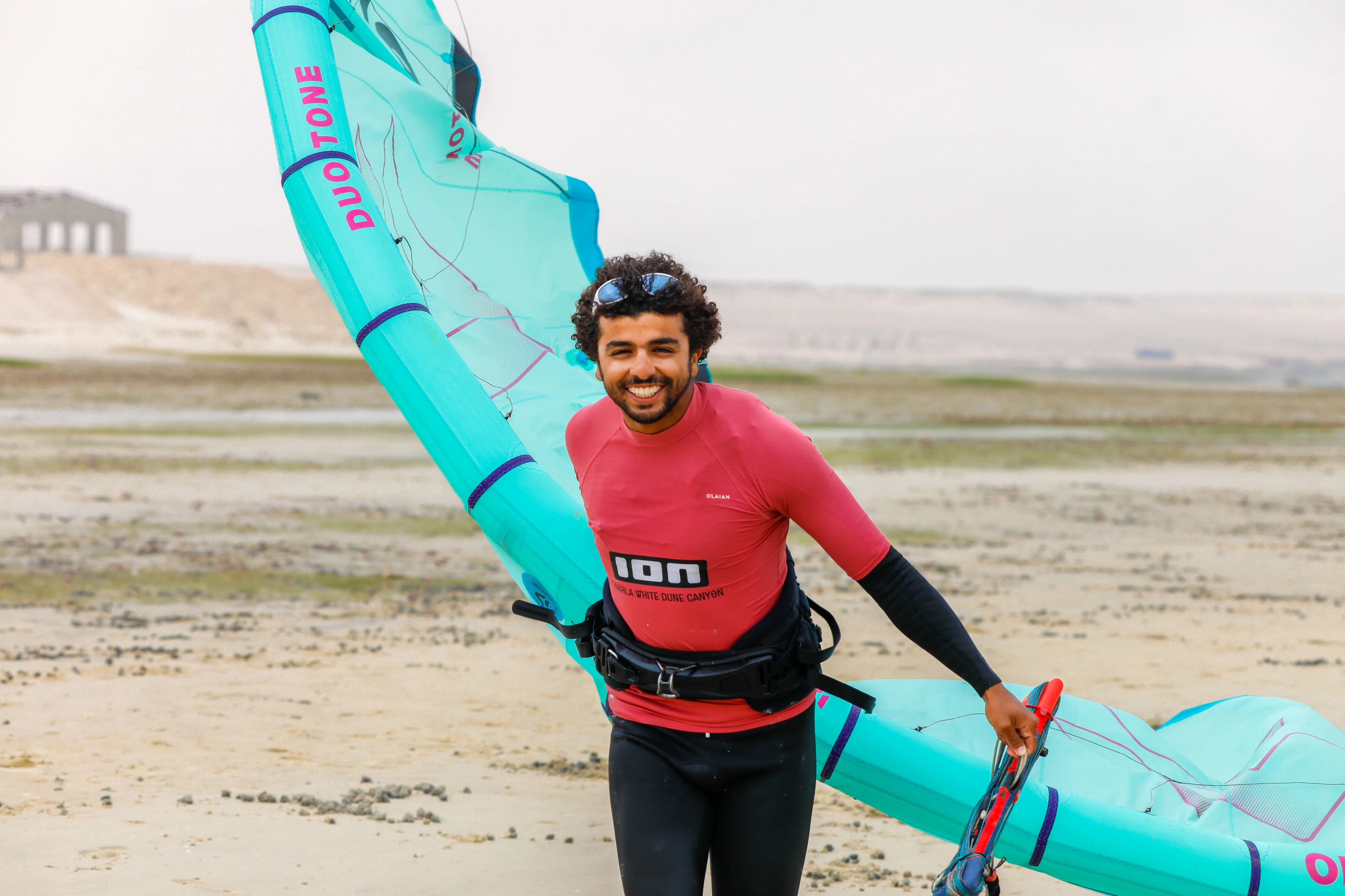 A kitesurfer launching from the beach in Dakhla with high-end rental equipment.