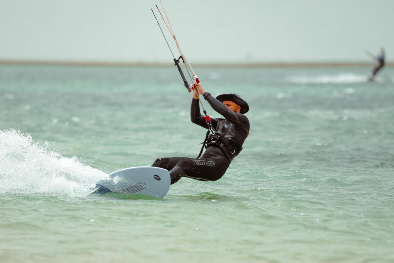 Client Bluboarding naviguant avec du matériel kitesurf de location sur l'eau plate du lagon de Dakhla.