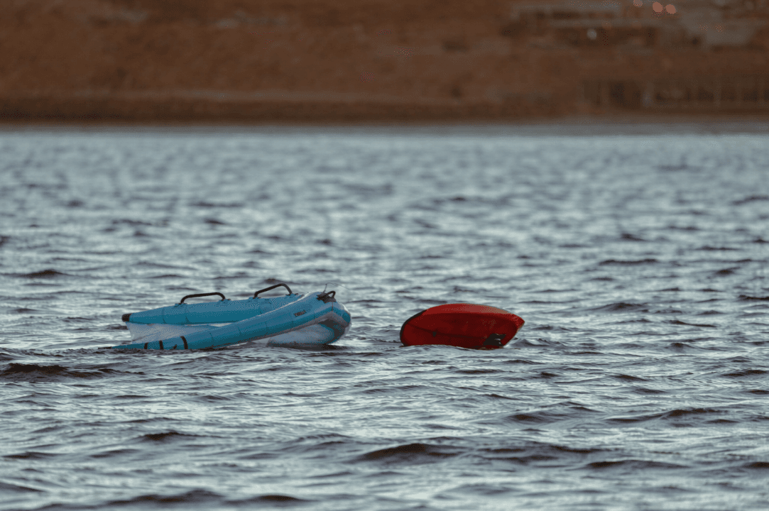 Planche et aile de wingfoil flottant sur l'eau turquoise du lagon de Dakhla, prêts à rider avec la location de matériel Bluboarding.