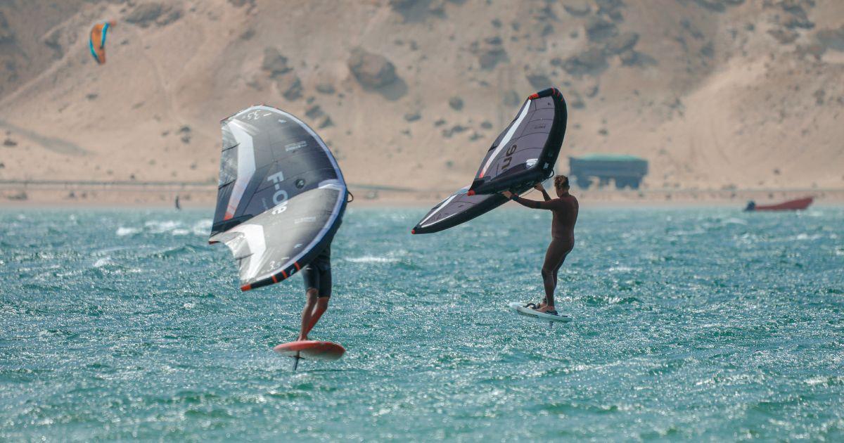 Deux clients Bluboarding avec du matériel wingfoil F-One de location sur l'eau plate du lagon de Dakhla.