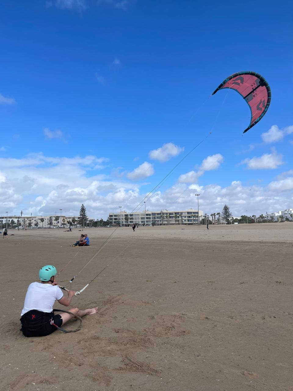 Client Bluboarding s'entraînant au contrôle du kite sur la plage d'Essaouira lors d'un cours privé de kitesurf.