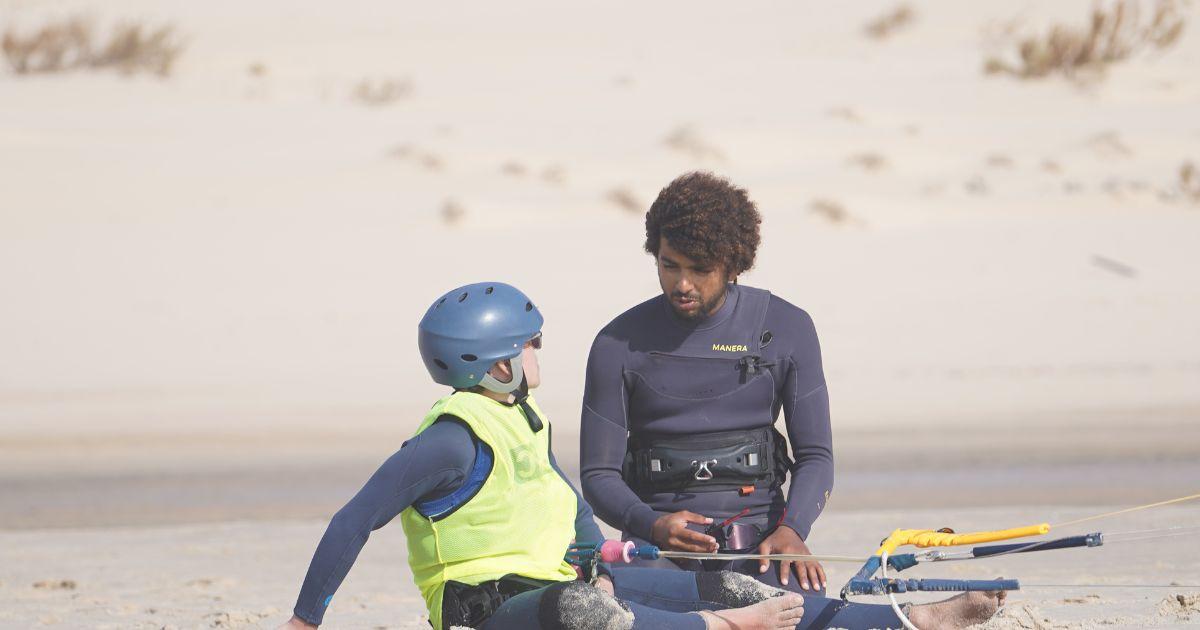 Bluboarding instructor talking to a young kitesurf student about building confidence on the flat water of the Dakhla lagoon.