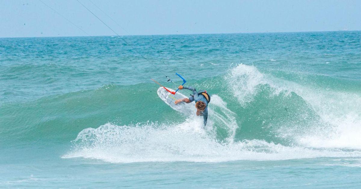 Bluboarding kitesurf instructor riding waves at Point d'Or spot near Dakhla, showcasing advanced wave kitesurfing skills.