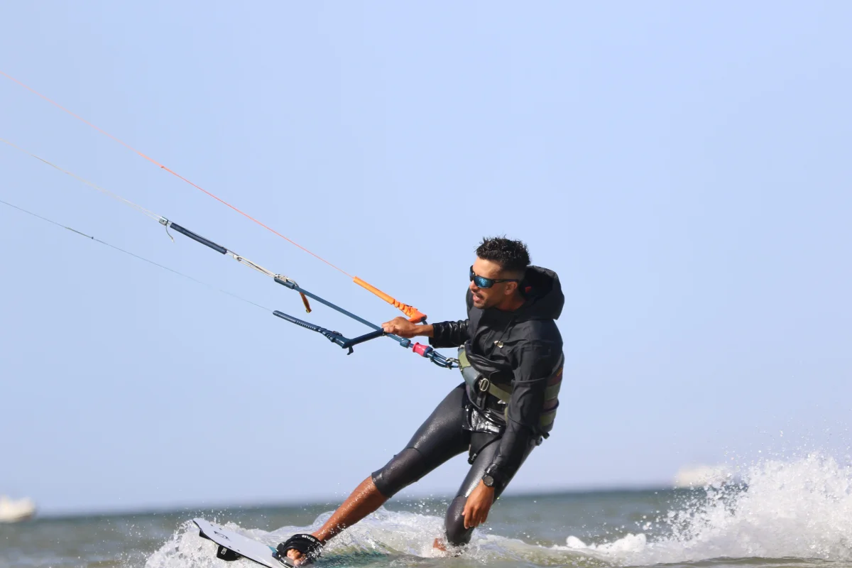 Bluboarding kitesurf instructor riding on the Dakhla lagoon and demonstrating toeside technique to his student during a kitesurf coaching session in Morocco.